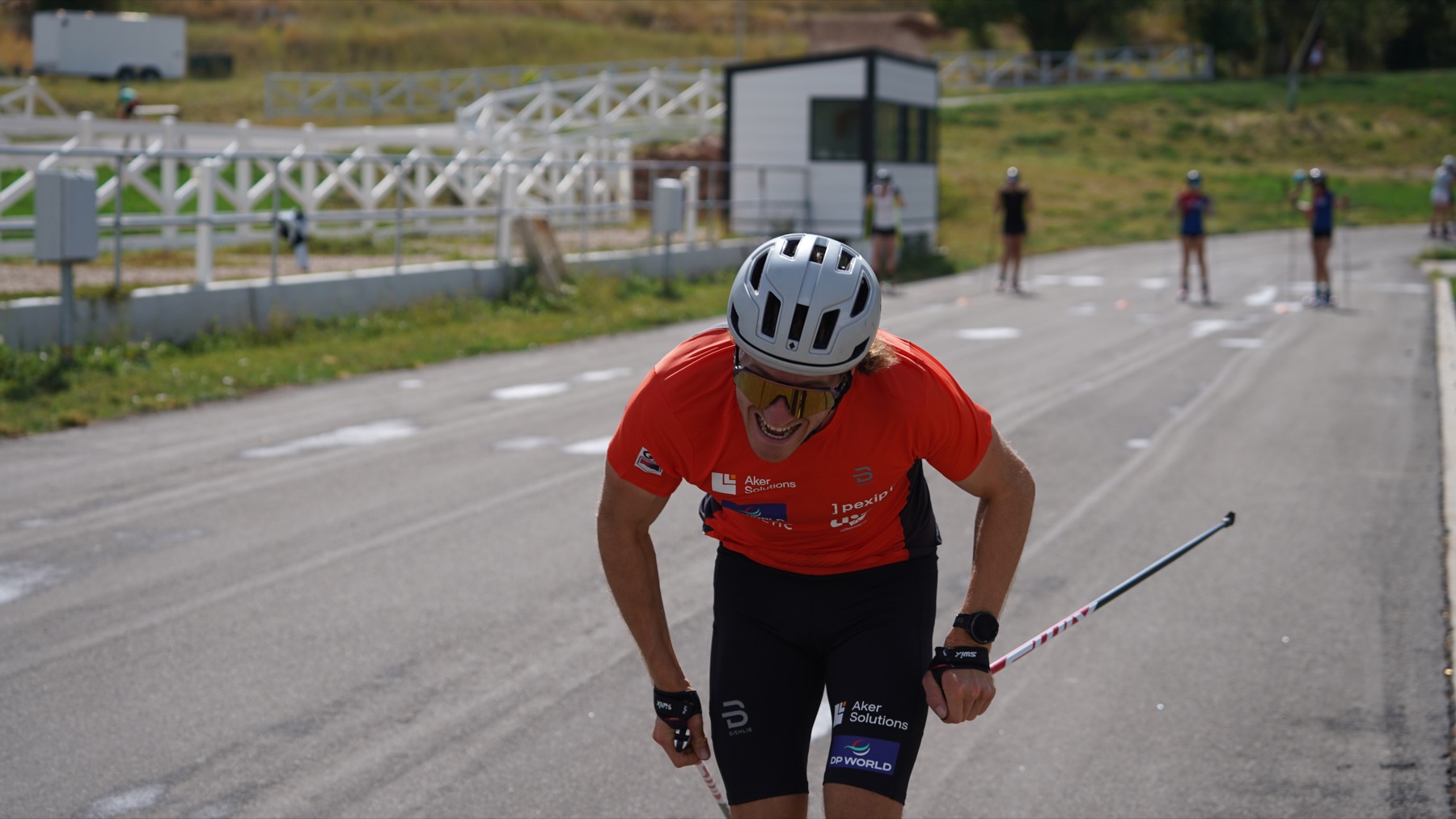Coaches sharing a light moment beside the rollerski track